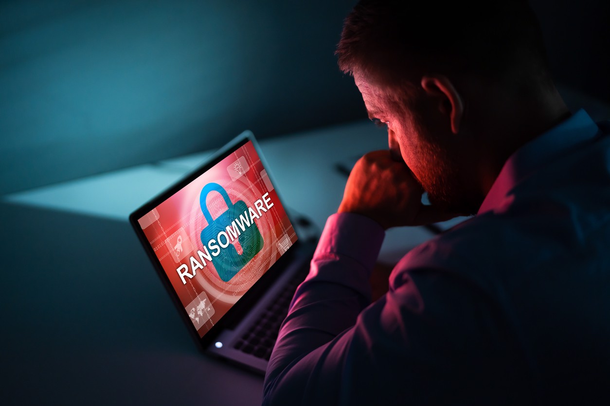 Person Looking At Laptop Screen Ransomware worauf Unternehmen achten sollten