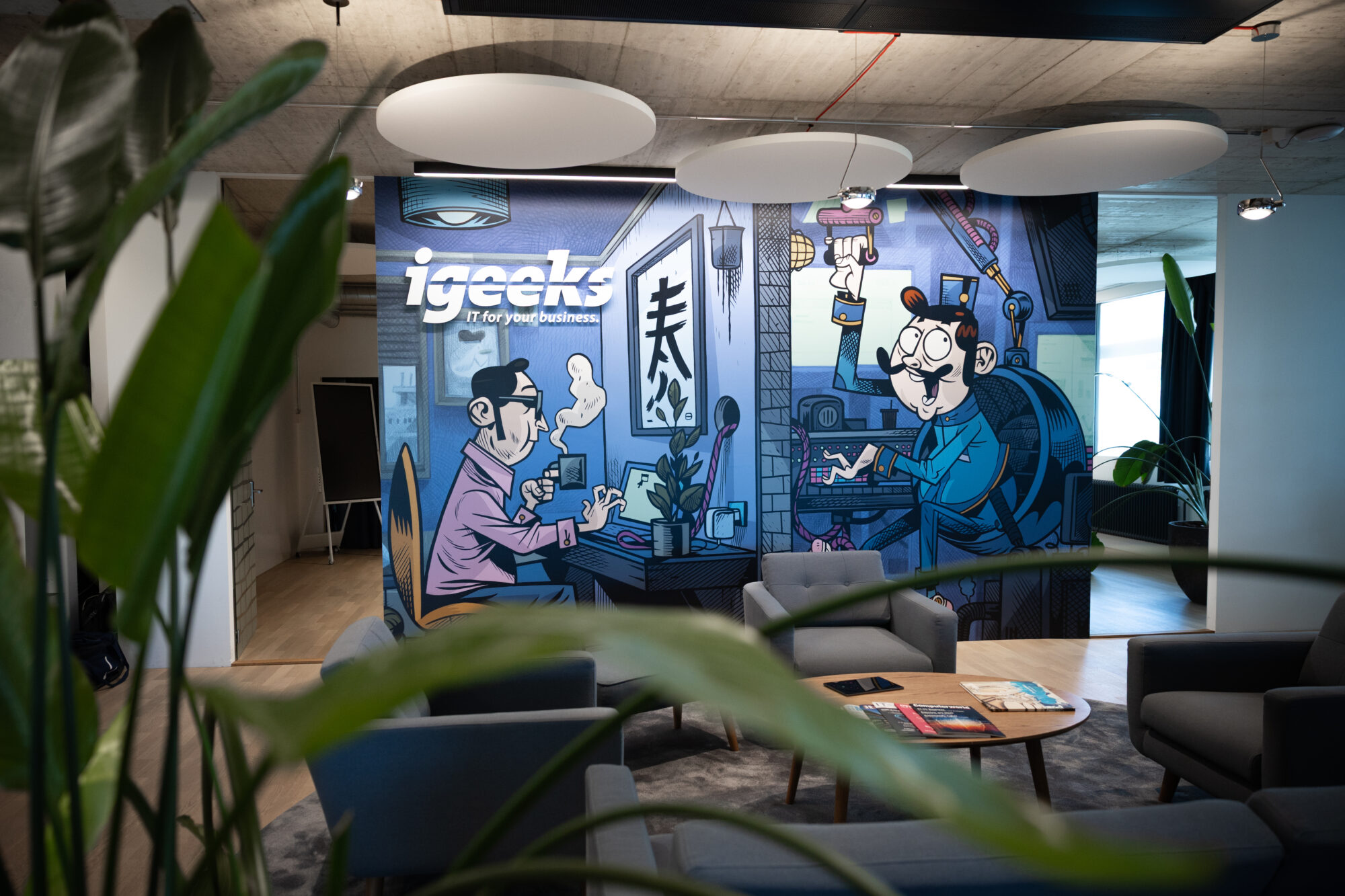 Lounge im igeeks Büro mit individuell gestalteter Wandillustration